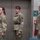 USARIEM COC/Relinquishment of Responsibility 2026 Three U.S. Army soldiers in Operational Camouflage Pattern (OCP) uniforms are standing at attention or parade rest in an indoor facility. Two are female and one is male, all wearing matching unit patches on their left shoulders. They appear to be participating in a formal military ceremony or official event.