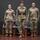 USARIEM COC/Relinquishment of Responsibility 2026 Three U.S. Army soldiers in Operational Camouflage Pattern (OCP) uniforms stand at attention on a stage, suggesting a formal military ceremony such as a change of command, promotion, or award presentation. Two females flank a central female soldier who appears to be the focal figure, distinguished by a dress belt. A burgundy/maroon unit guidon flag is partially visible on the left side of the stage.