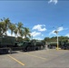 Military Water Trucks Staged in Tropical Parking Lot Behind Security Barriers