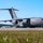 A U.S. Air Force C-17 Globemaster III military transport aircraft with tail number 0194, assigned to the 445th Airlift Wing, is parked on a flight line tarmac. Ground crew personnel are visible around the aircraft performing what appears to be pre- or post-flight servicing operations. The image was taken on a clear, sunny day at what appears to be a military airfield.