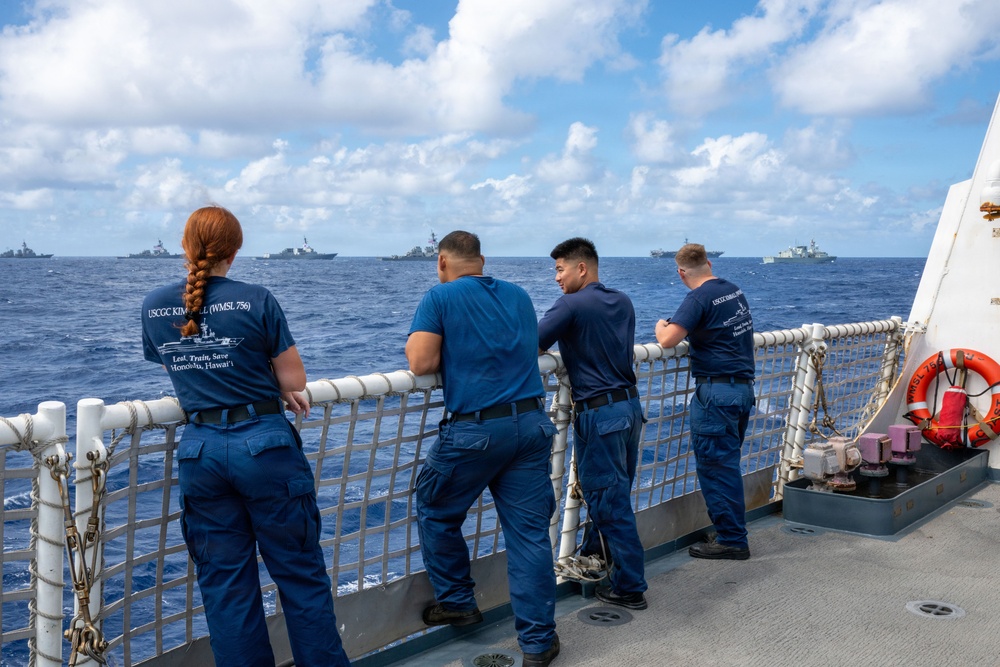 U.S. Coast Guardsmen observe multinational ships sail in formation during RIMPAC 2026