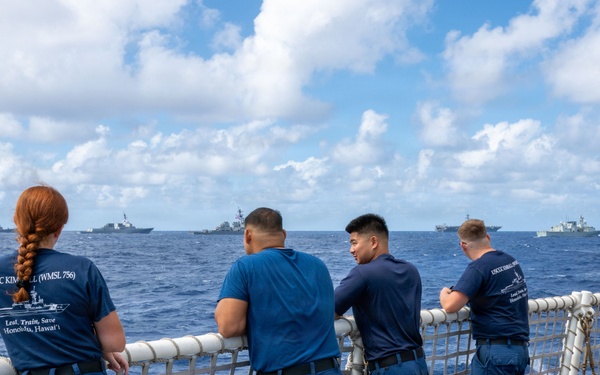 U.S. Coast Guardsmen observe multinational ships sail in formation during RIMPAC 2026