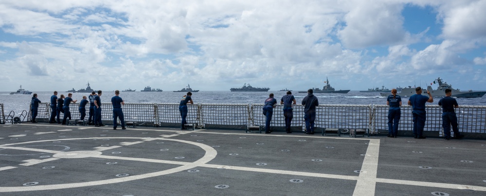 U.S. Coast Guardsmen observe multinational ships sail in formation during RIMPAC 2026