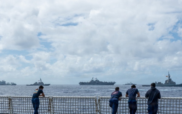 U.S. Coast Guardsmen observe multinational ships sail in formation during RIMPAC 2026