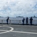 U.S. Coast Guardsmen observe multinational ships sail in formation during RIMPAC 2026