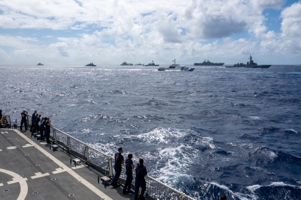 U.S. Coast Guardsmen observe multinational ships sail in formation during RIMPAC 2026