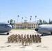 A formal group photograph of U.S. Air Force personnel assembled on the flight line at March Field (March Air Reserve Base), California. Two military aircraft flank the formation — a C-17 Globemaster III (tail number 5144, 452nd AMW) on the left and a KC-135 Stratotanker on the right. The historic March Field headquarters building is visible in the background with an American flag flying above it.