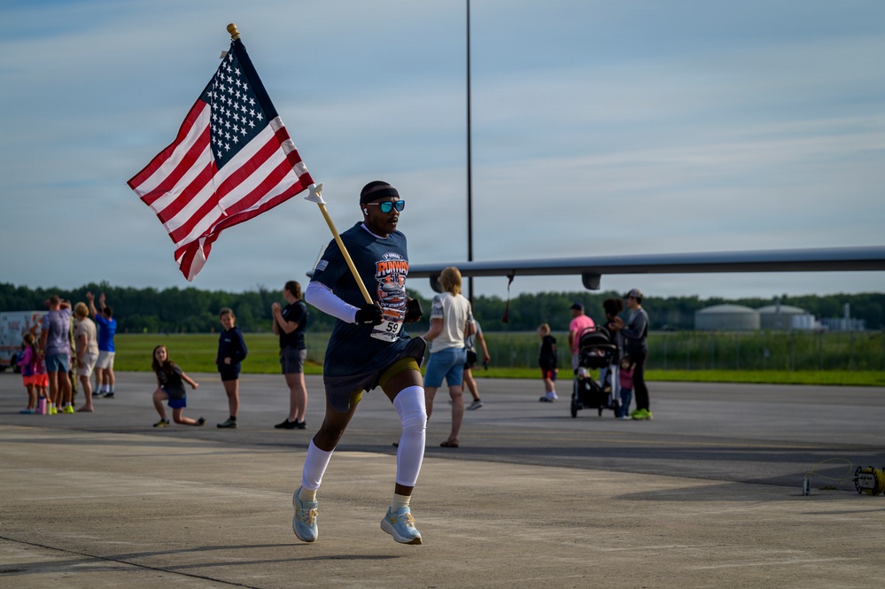 Staff Sgt. Kibingira Carries U.S. Flag Across Runway 5K Finish Line