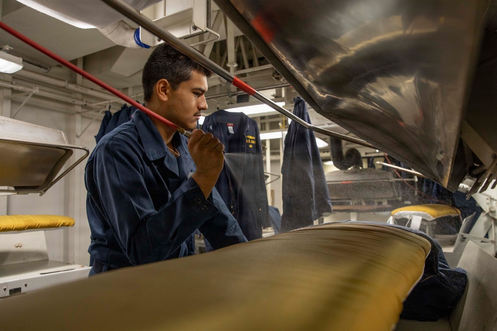 U.S. Navy Sailor Prepares Uniform for Press