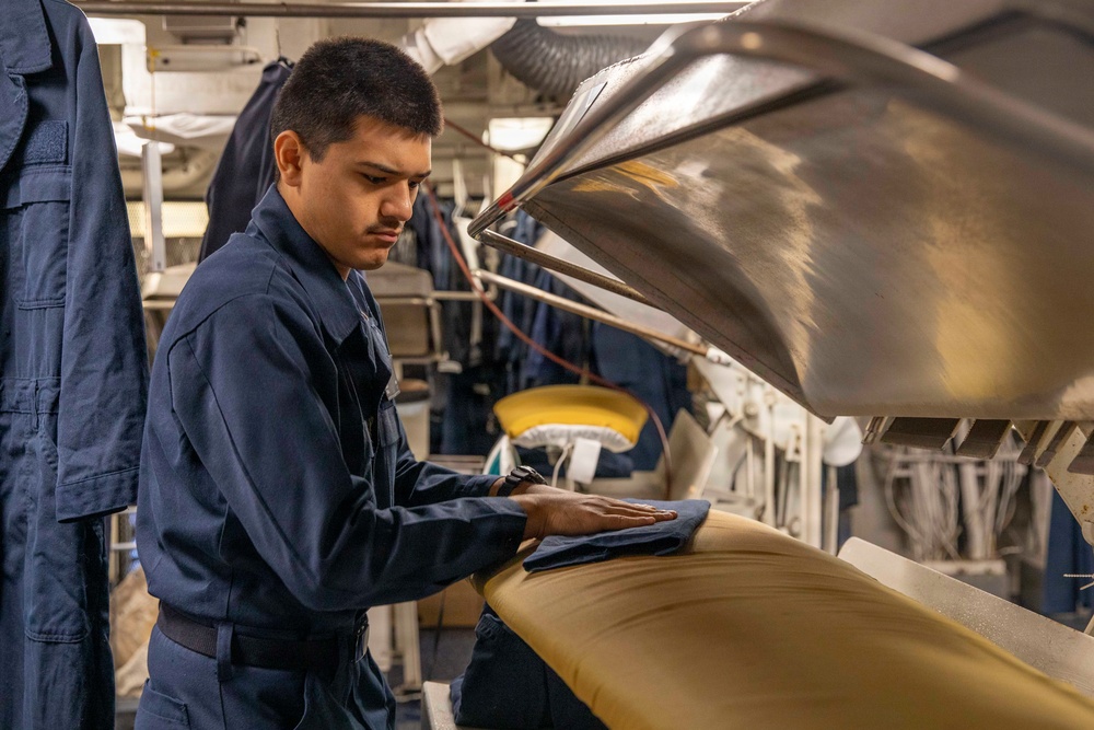 U.S. Navy Sailor Prepares Uniform for Press