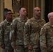 Four U.S. Army soldiers in Operational Camouflage Pattern (OCP) uniforms are standing at attention in what appears to be a formal indoor ceremony. Name tapes visible on their uniforms read 'BRITTAIN', 'CHAVEZ', 'FOUST', and 'WATERS' (partially visible). Unit patches including the 3rd Infantry Division and 101st Airborne Division are visible on their sleeves.