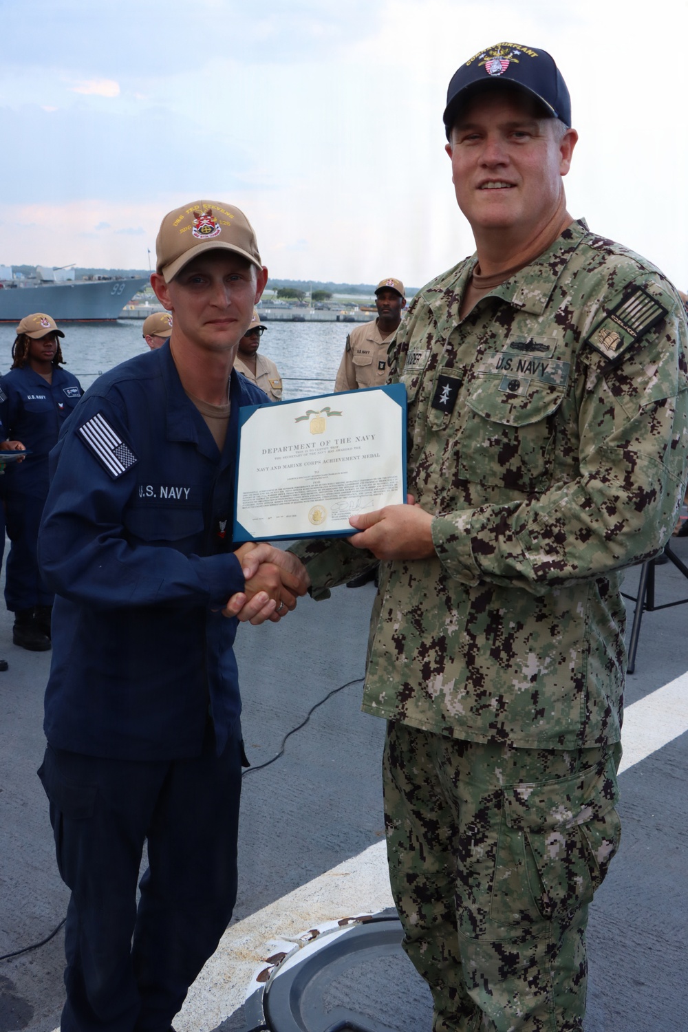 Rear Adm. Christopher Alexander, commander, Naval Surface Force Atlantic (SURFLANT), presents Logistics Specialist 2nd Class Charles Russo with the Navy and Marine Corps Achievement Medal.