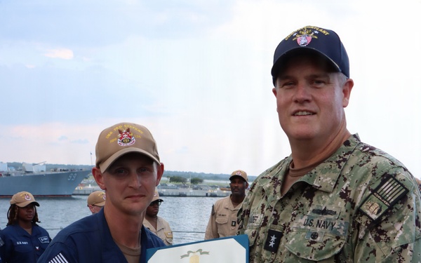 Rear Adm. Christopher Alexander, commander, Naval Surface Force Atlantic (SURFLANT), presents Logistics Specialist 2nd Class Charles Russo with the Navy and Marine Corps Achievement Medal.