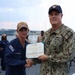 Rear Adm. Christopher Alexander, commander, Naval Surface Force Atlantic (SURFLANT), presents Logistics Specialist 2nd Class Charles Russo with the Navy and Marine Corps Achievement Medal.