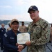 Rear Adm. Christopher Alexander, commander, Naval Surface Force Atlantic (SURFLANT), presents Electrician’s Mate Fireman Frank Velasquez-Ramirez with the Navy and Marine Corps Achievement Medal.