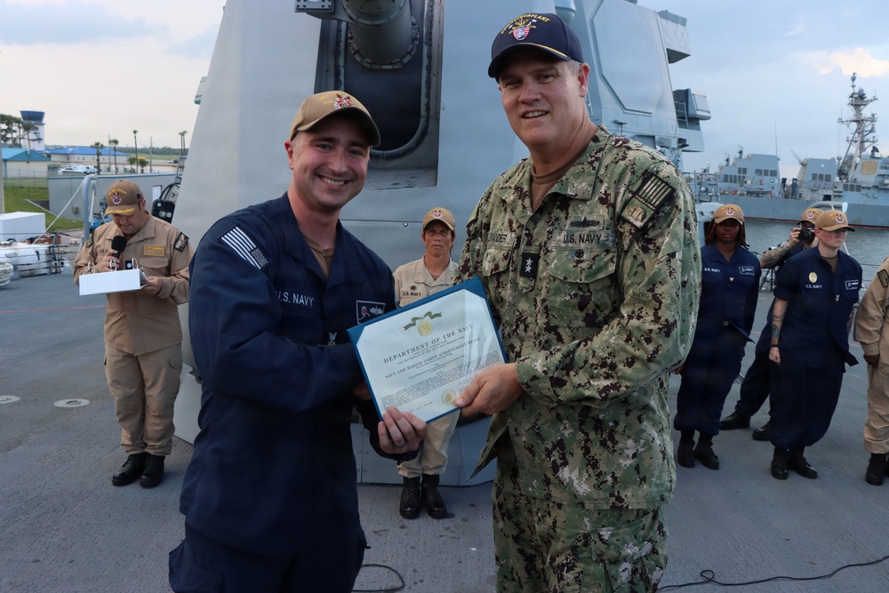 Rear Adm. Christopher Alexander, commander, Naval Surface Force Atlantic (SURFLANT), presents Fire Controlman 1st Class Kevin Hurd with the Navy and Marine Corps Achievement Medal.