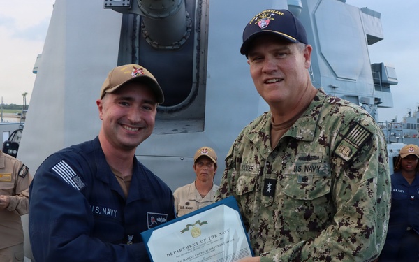 Rear Adm. Christopher Alexander, commander, Naval Surface Force Atlantic (SURFLANT), presents Fire Controlman 1st Class Kevin Hurd with the Navy and Marine Corps Achievement Medal.