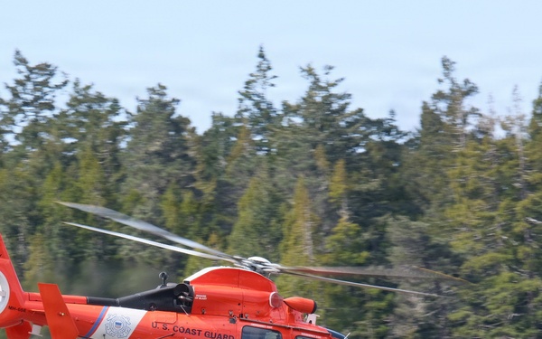 U.S. Coast Guard MH-65 Dolphin Helicopter 6603 in Flight Near Forested Coastline