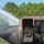 Gulfport CRTC Live Fire Training Exercise A firefighter in full protective gear is visible inside or near the doorway of a heavily rusted, burned aircraft fuselage during what appears to be a firefighting training exercise. A powerful water stream is being directed at the nose section of the aircraft from the left side. Smoke is visible emanating from the aircraft's windows and interior.