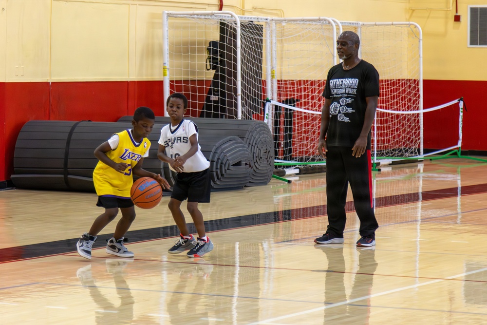 U.S. Marines and local community members participate in a pickup basketball game