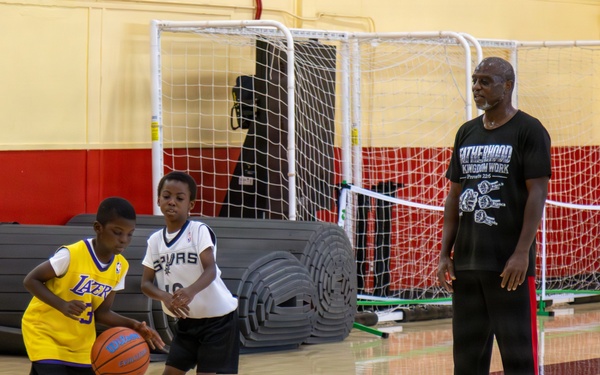 U.S. Marines and local community members participate in a pickup basketball game