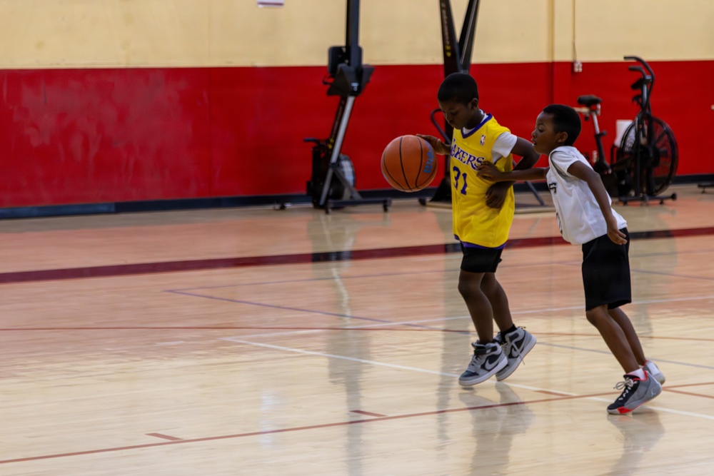 U.S. Marines and local community members participate in a pickup basketball game