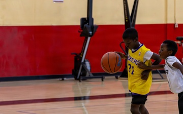 U.S. Marines and local community members participate in a pickup basketball game