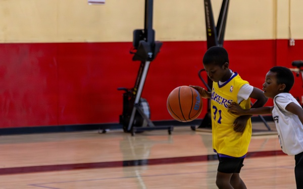 U.S. Marines and local community members participate in a pickup basketball game