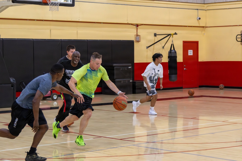 U.S. Marines and local community members participate in a pickup basketball game