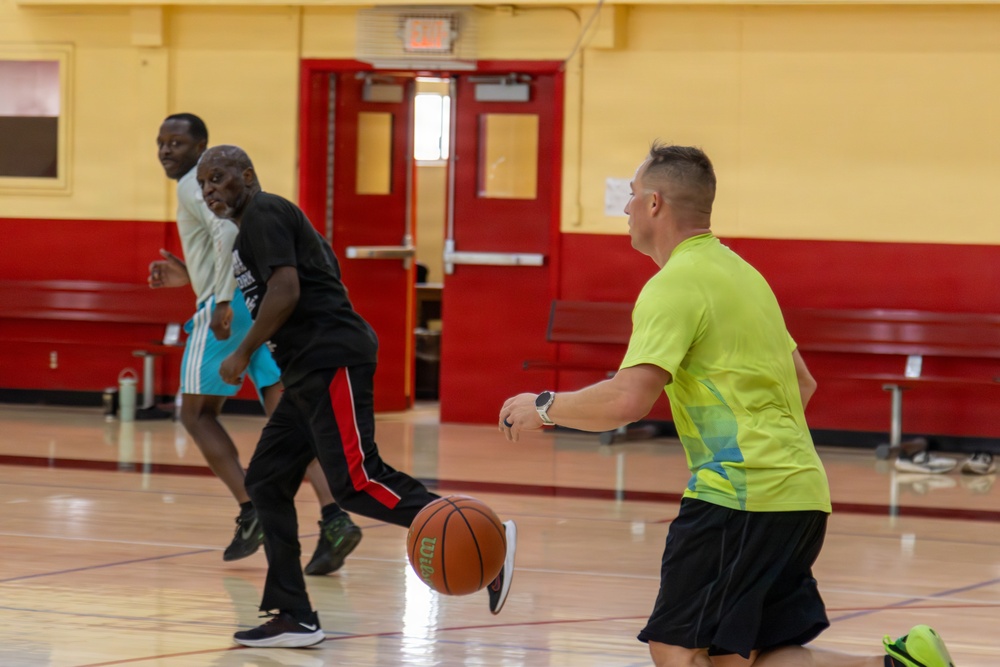 U.S. Marines and local community members participate in a pickup basketball game