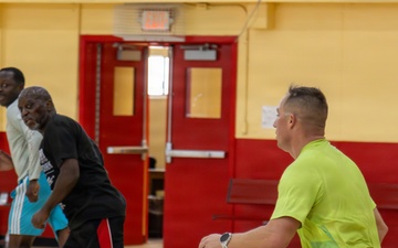 U.S. Marines and local community members participate in a pickup basketball game