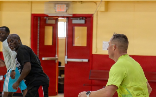 U.S. Marines and local community members participate in a pickup basketball game