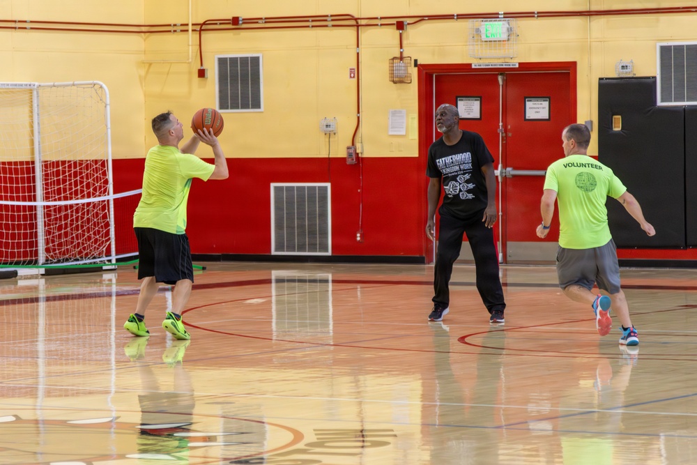 U.S. Marines and local community members participate in a pickup basketball game