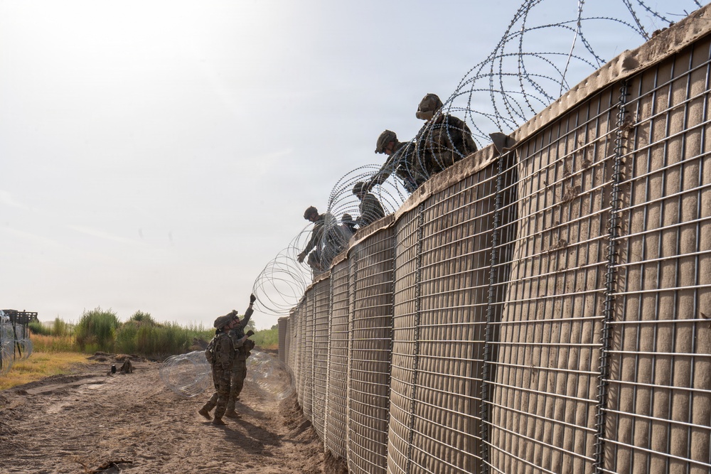591st Engineer Company places Concertina Wire on top of HESCO barriers at NDA 2