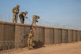 591st Engineer Company places Concertina Wire on top of HESCO barriers at NDA 2