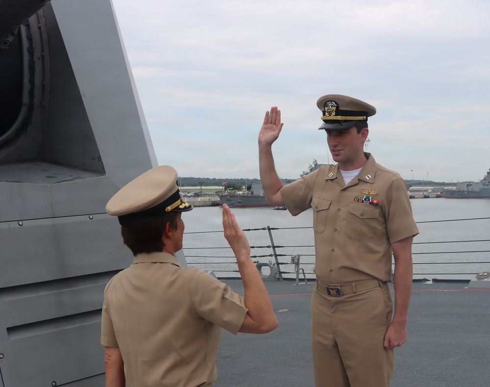 Captain Mary Hays, Commanding Officer, USS Ted Stevens (DDG 128), promotes Weapons Officer, LT Zachary Wasson, to the rank of Lieutenant Commander.