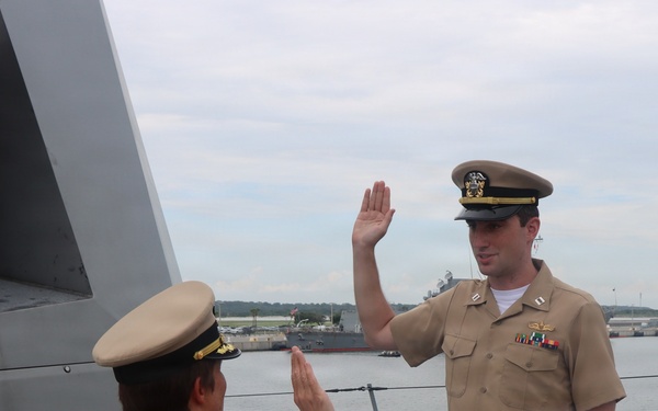 Captain Mary Hays, Commanding Officer, USS Ted Stevens (DDG 128), promotes Weapons Officer, LT Zachary Wasson, to the rank of Lieutenant Commander.