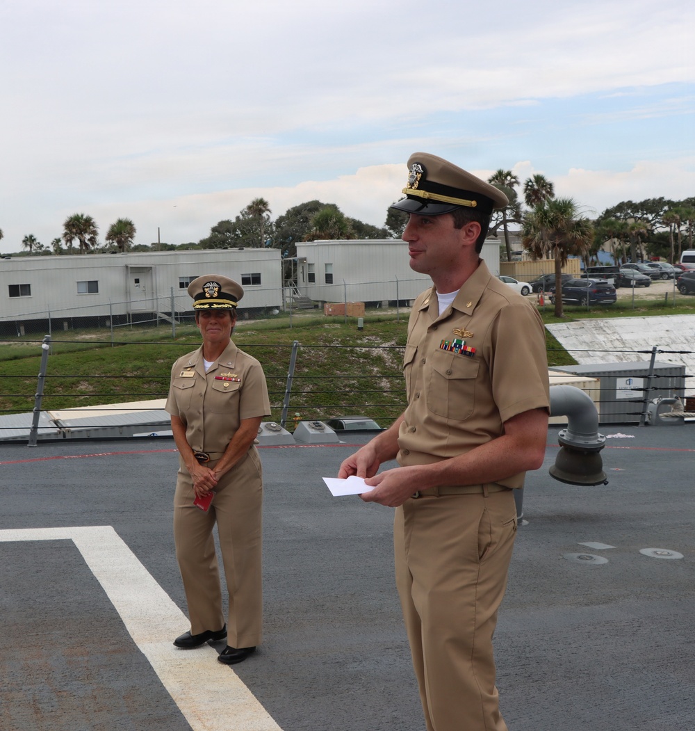 Captain Mary Hays, Commanding Officer, USS Ted Stevens (DDG 128), promotes Weapons Officer, LT Zachary Wasson, to the rank of Lieutenant Commander.
