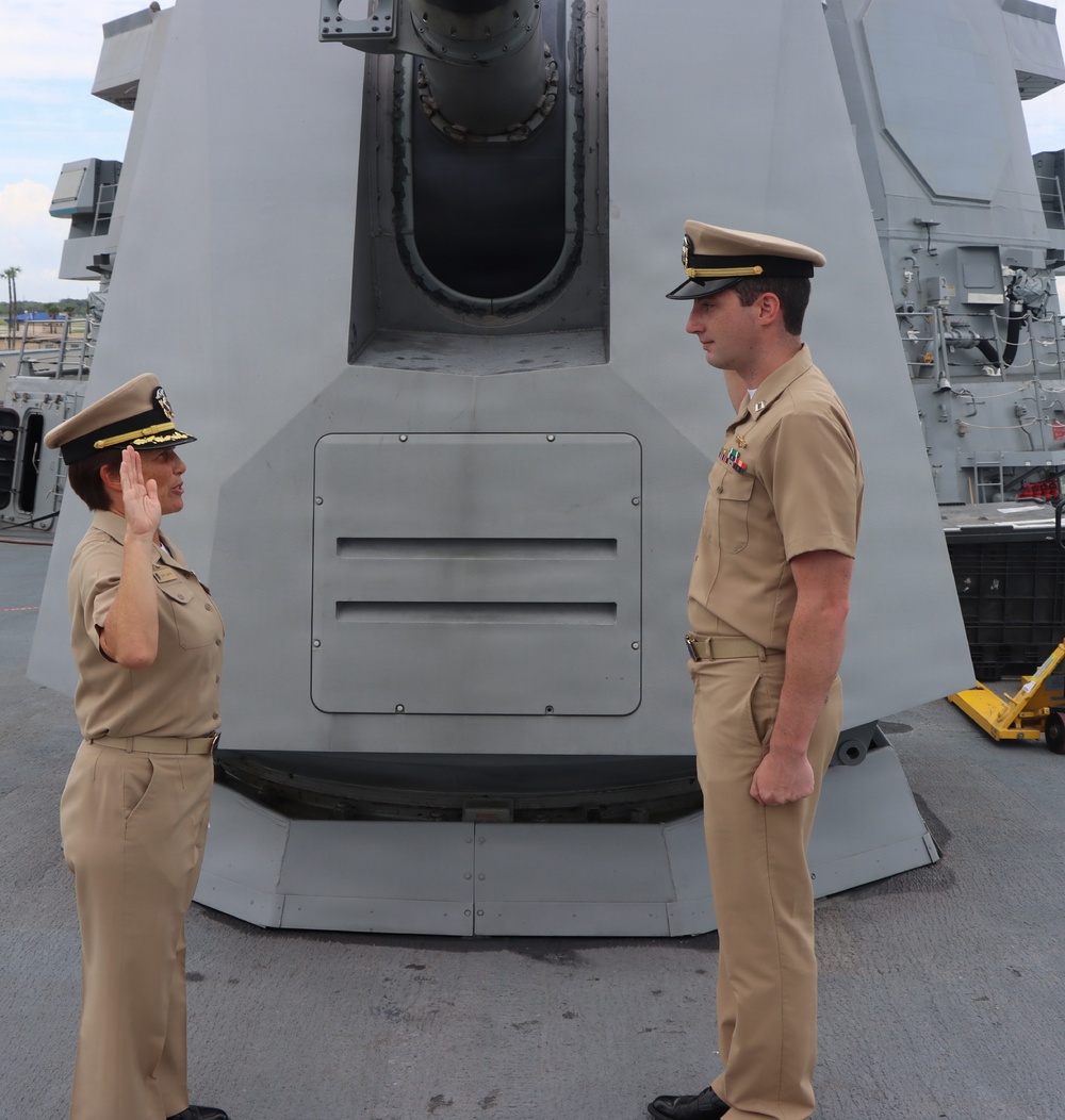 Captain Mary Hays, Commanding Officer, USS Ted Stevens (DDG 128), promotes Weapons Officer, LT Zachary Wasson, to the rank of Lieutenant Commander.