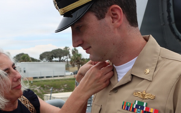 Captain Mary Hays, Commanding Officer, USS Ted Stevens (DDG 128), promotes Weapons Officer, LT Zachary Wasson, to the rank of Lieutenant Commander. He was pinned to his new rank by his mother.