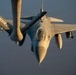 An aerial photograph captures an F-16 Fighting Falcon jet fighter during an in-flight refueling operation. The aircraft bears the markings 'KANSAS' on the wing and 'COYOTES' on the fuselage, indicating it belongs to a Kansas Air National Guard unit. The image is taken from the perspective of the tanker aircraft, with the refueling boom visible in the foreground.