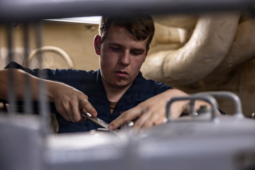 Sailors Conduct Routine Maintenance In Engine Room