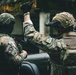 Two armed military personnel in full tactical gear are shown from behind, with one soldier giving a hand signal. The soldier on the left displays a Panamanian flag patch, while the soldier on the right displays an Ecuadorian flag patch on their helmet, suggesting a joint or multinational military operation. Both are equipped with helmets, plate carriers, tactical gloves, and firearms.