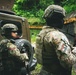 Two armed military or special operations personnel are standing near a tactical vehicle in a jungle or forested environment. The soldier on the left displays an Ecuadorian flag patch and unit insignia, while the soldier on the right displays a Panamanian flag patch and carries a weapon slung over their shoulder. The setting suggests a joint military operation or training exercise between Ecuadorian and Panamanian forces.