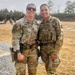Two female U.S. Army soldiers in Operational Camouflage Pattern (OCP) uniforms pose together at what appears to be a military firing range. The soldier on the left displays a name tape reading 'HAMELLY' and a Sergeant First Class rank insignia, along with a 3rd Infantry Division patch. The setting includes shooting targets, gravel lanes, and additional soldiers visible in the background.