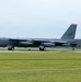 A U.S. Air Force B-52 Stratofortress strategic bomber is landing on a runway with its yellow drag parachute deployed for deceleration. The aircraft bears the tail code 'MT' and serial number '0060', indicating it belongs to the Montana-based 5th Bomb Wing at Minot Air Force Base. A control tower with 'Offutt AFB' signage is visible in the background, suggesting this was taken at Offutt Air Force Base, Nebraska.
