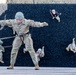 Military personnel are conducting rappelling training on a large wall structure. The central figure, identified by helmet number '604' and name tape 'NESSA', is descending face-forward in a Australian/commando rappel stance with arms outstretched. Multiple other trainees and at least one instructor in civilian attire are visible at various stages of the exercise.