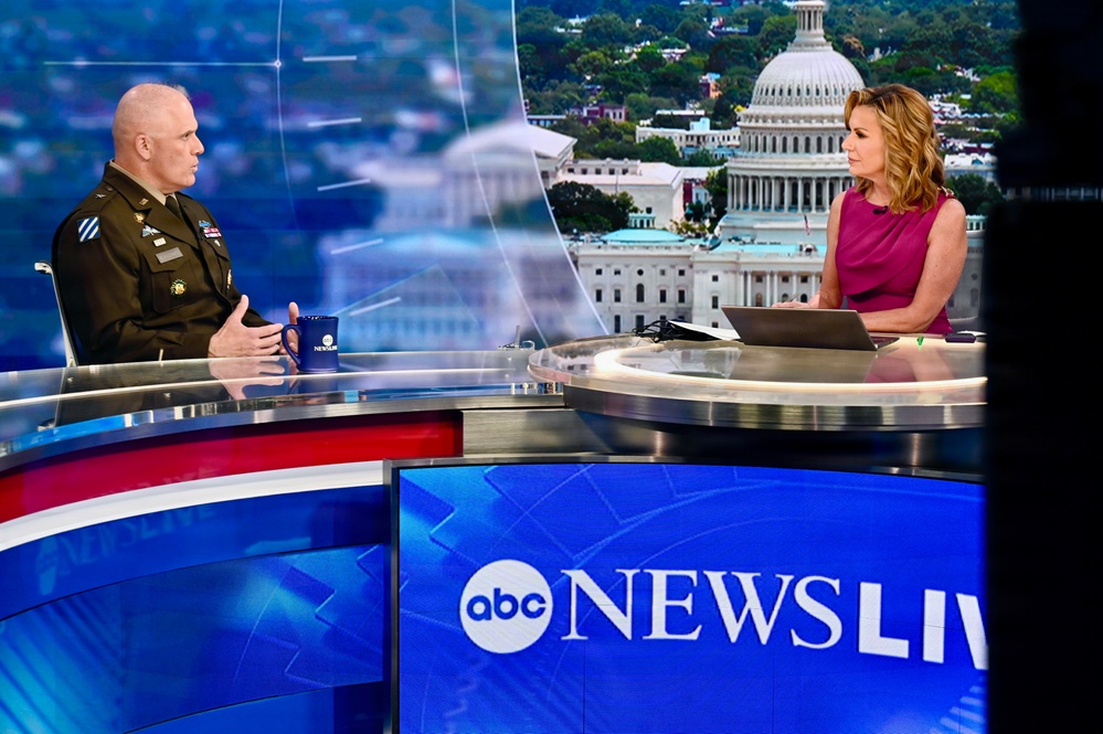 A U.S. Army officer in military dress uniform is being interviewed on the ABC News Live television program by a female anchor. They are seated at a curved news desk with a digitally projected backdrop showing the U.S. Capitol building. The ABC News Live logo is prominently displayed on a screen in the foreground.