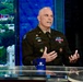 A U.S. Army officer named Blanchard, as indicated by the name tape on his uniform, is seated at a news desk during a live broadcast on ABC News Live. He is wearing an olive green Army service uniform adorned with multiple medals, badges, and insignia, and appears to be speaking or being interviewed. The setting is a modern television studio with a blue-lit backdrop and a city/landscape view visible through a window.