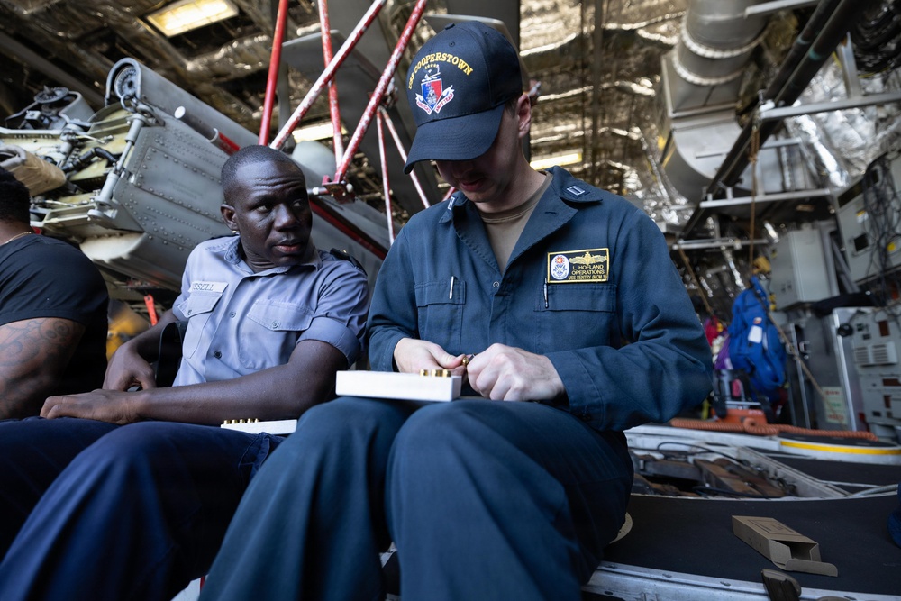 U.S. Navy and RBDF officers load pistol magazines